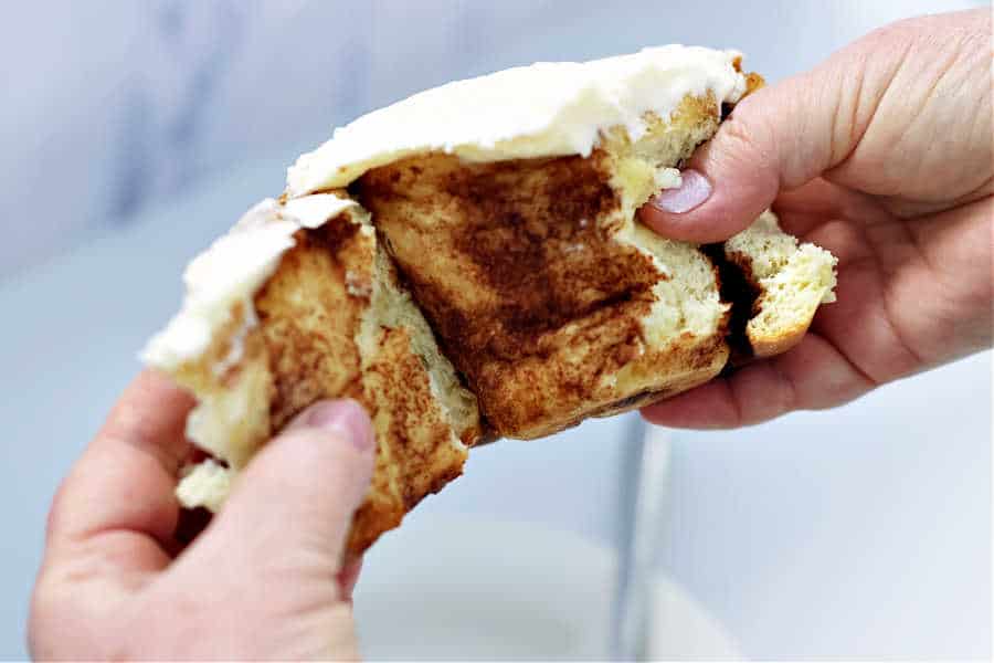 Cinnamon Roll being pulled apart by two hands