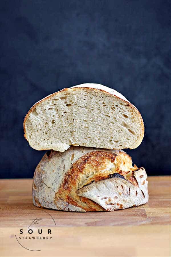 Sourdough boule cut in half and stacked on top of each other showing a tight crumb from low hydration dough